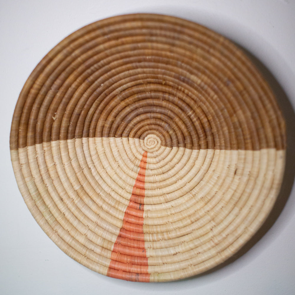 JustOne's two-toned tan basket with small pink sliver, handwoven in Uganda