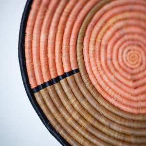 JustOne's tan and pink basket handwoven in Uganda
