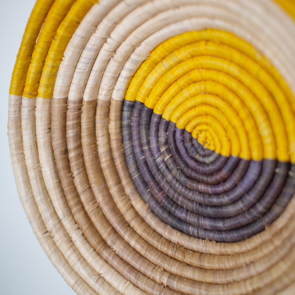 JustOne's yellow, tan, and grey wall basket handwoven in Uganda