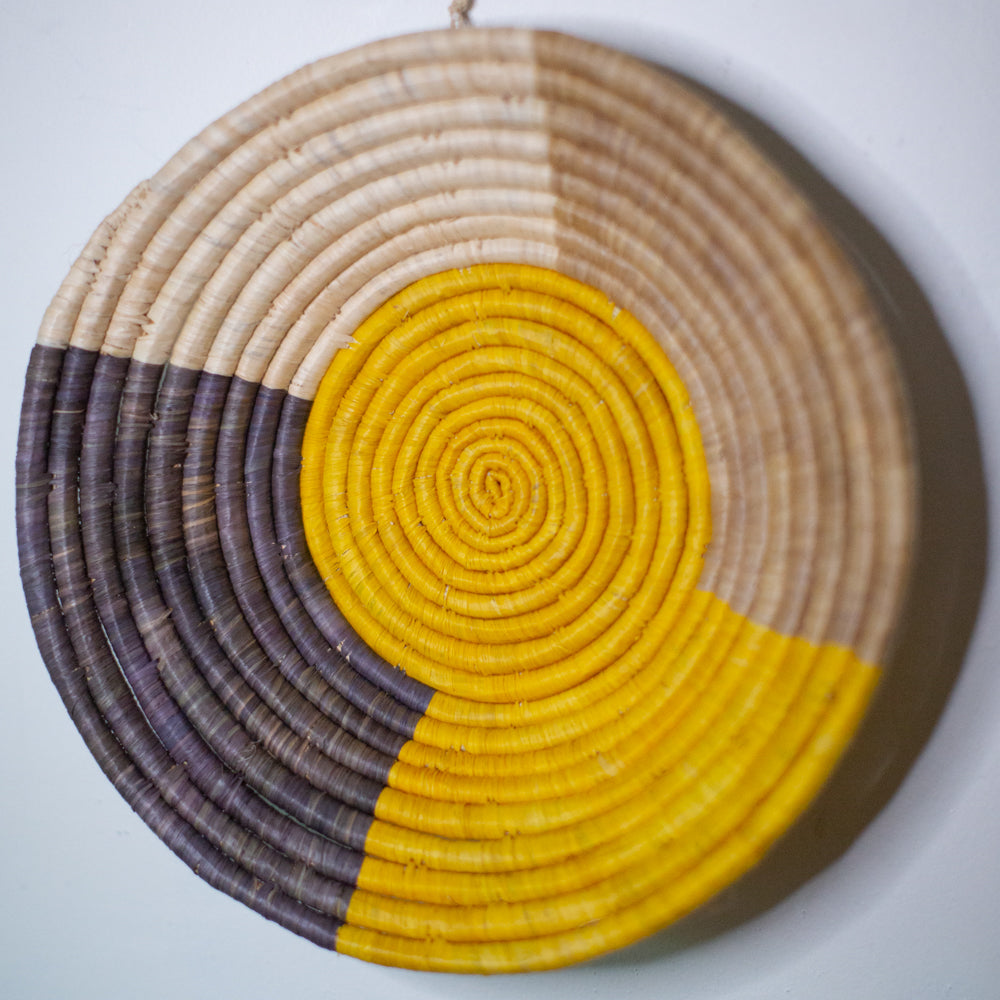 JustOne's wall basket with yellow grey and tan in quarter sections, handwoven in Uganda