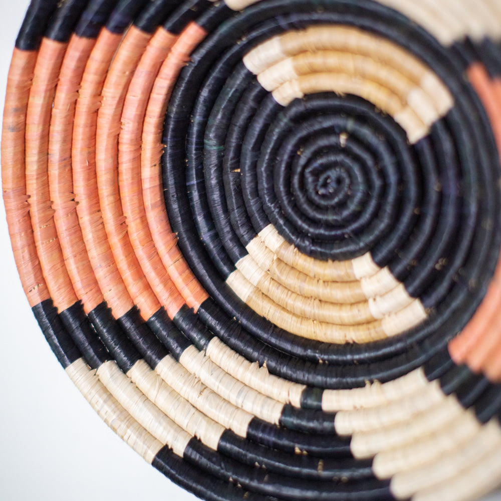 JustOne's pink, black, and tan hanging basket handwoven in Uganda