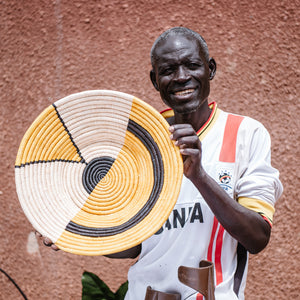 JustOne's yellow, black, and tan wall basket, handwoven in Uganda