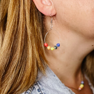 JustOne's silver dangly hoop earrings with five beads to make a rainbow handmade in Uganda