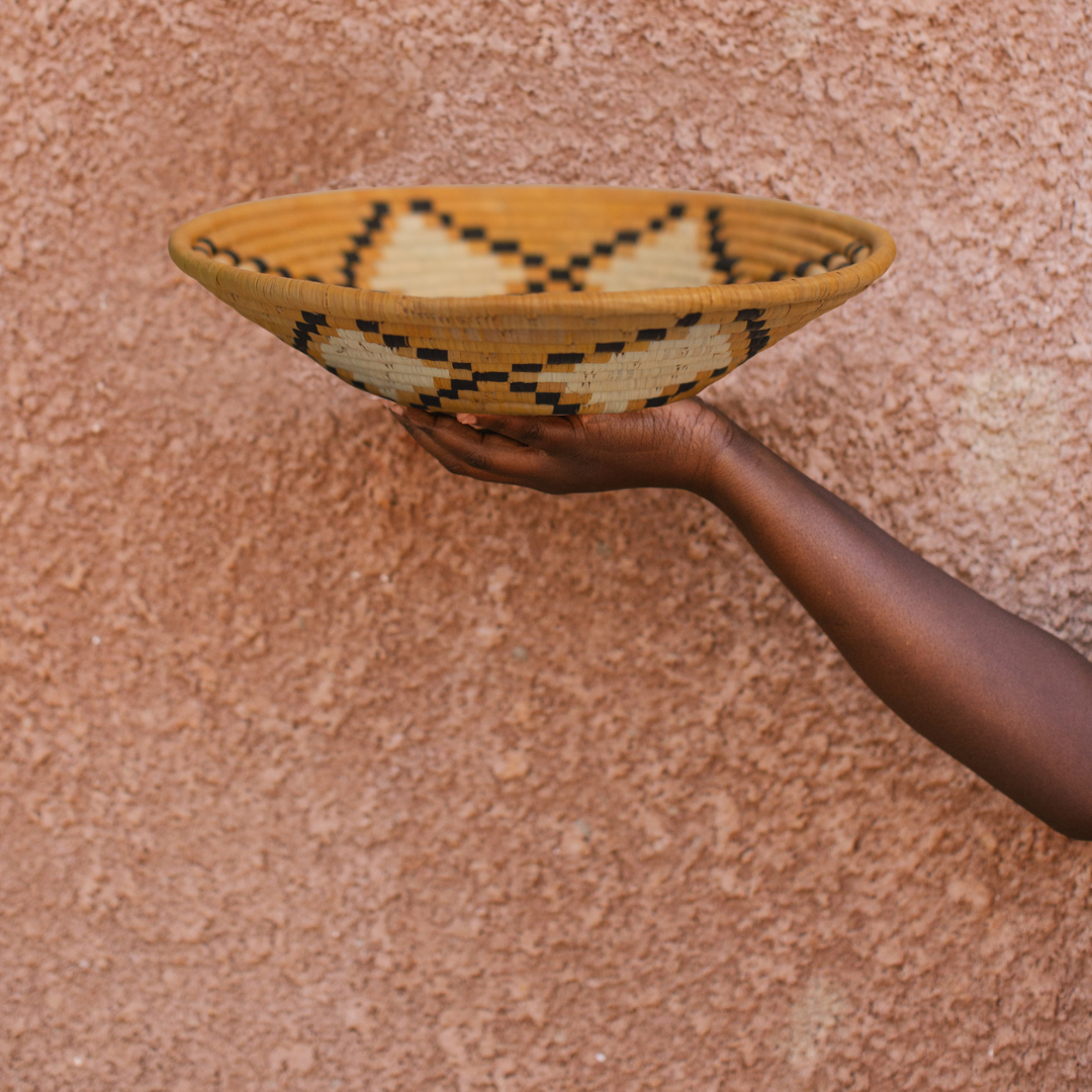 JustOne's yellow, tan, and black star design wall basket handwoven in Uganda