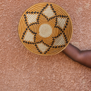 JustOne's yellow, tan, and black star design wall basket, handwoven in Uganda