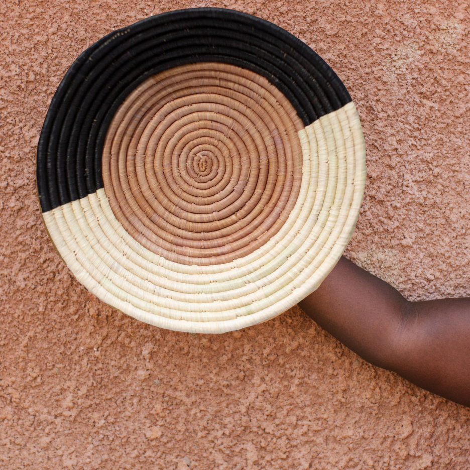 JustOne's tan with a black and natural border wall basket, handwoven in Uganda