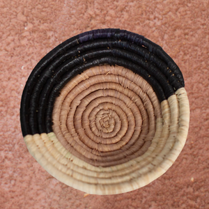 JustOne's small tan basket with black and natural border, handwoven in Uganda
