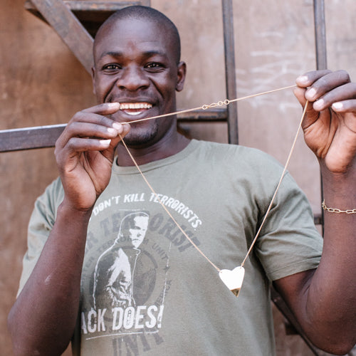 JustOne's long brass necklace with large white and brass heart charm made from ethically sourced bone and brass, handcrafted in Kenya