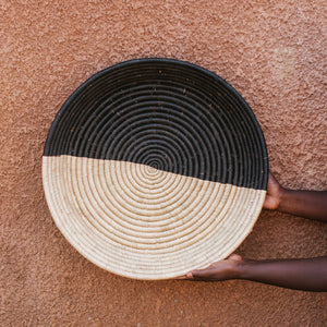 JustOne's half black, half tan wall basket, handwoven in Uganda