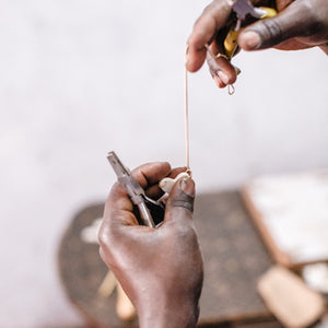 JustOne's long brass necklace with large white and brass heart charm made from ethically sourced bone and brass, handcrafted in Kenya