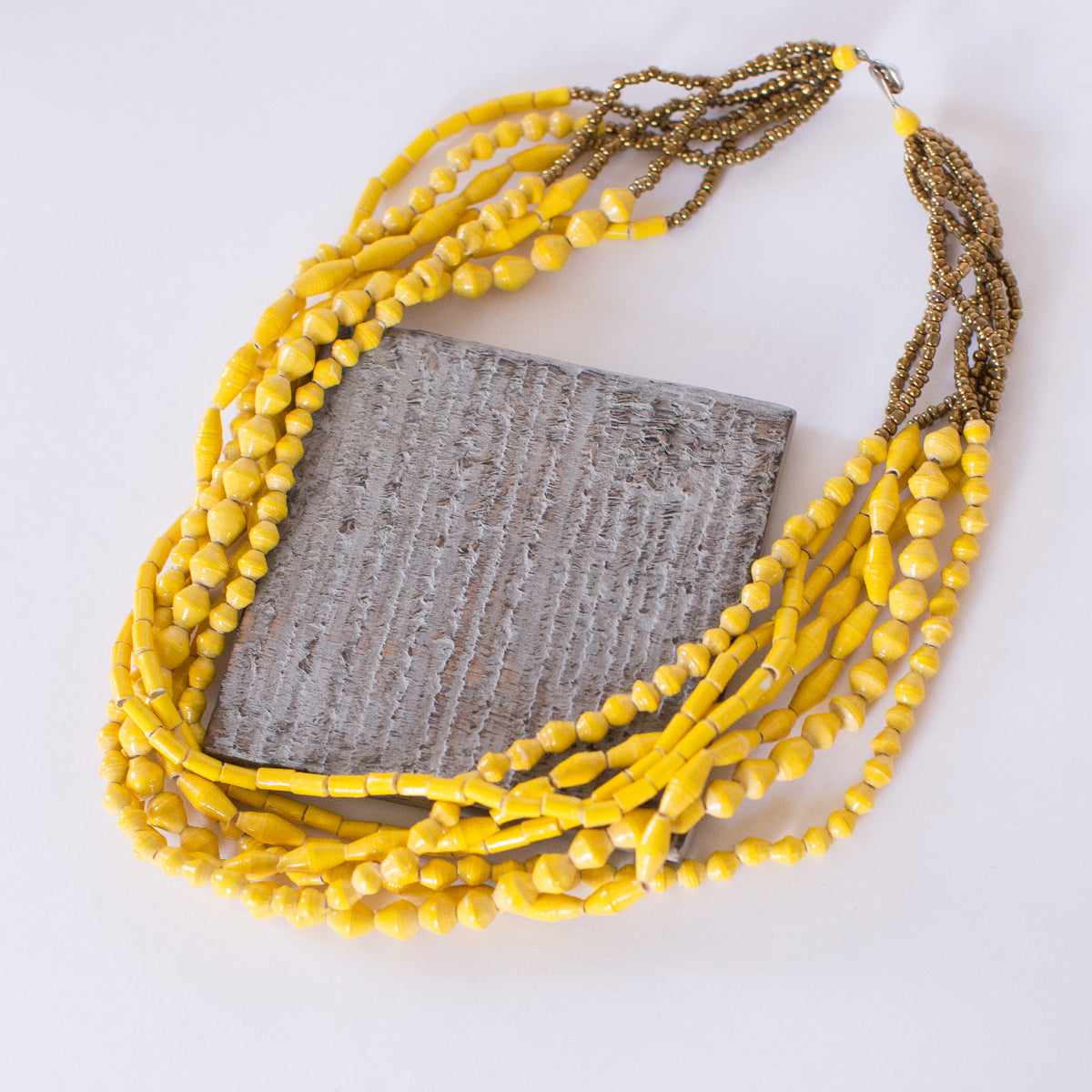 JustOne's chunky yellow necklace with seven strands of paper beads to create the one necklace, handmade in Uganda