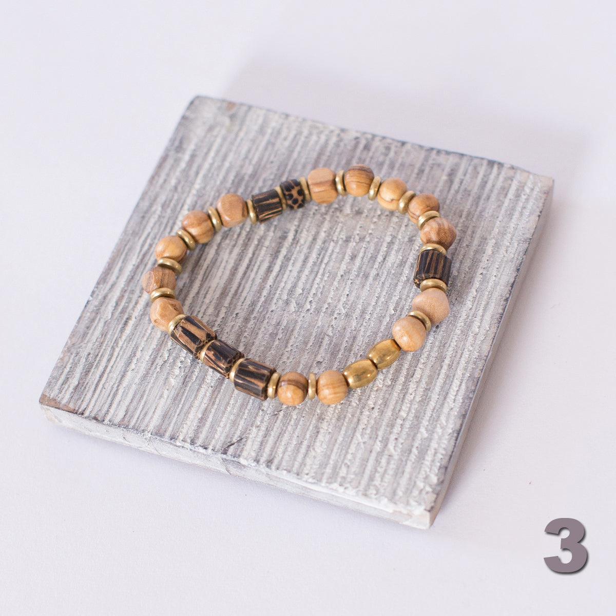 JustOne's stretch bracelet made with handcrafted wooden beads and brass rings, handcrafted in Kenya
