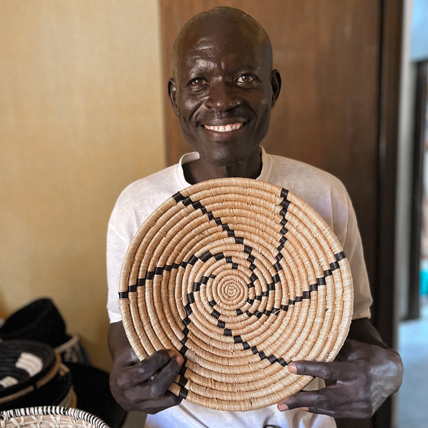 JustOne's tan basket with black lines handwoven in Uganda