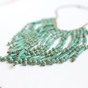 JustOne's necklace with several dangling strings of paper beads in teal, handcrafted in Uganda