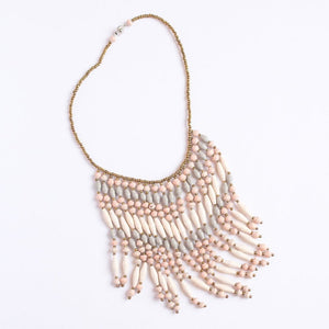 JustOne's necklace with several dangling strings of paper beads in muted grey, pink, and tan colours, handcrafted in Uganda