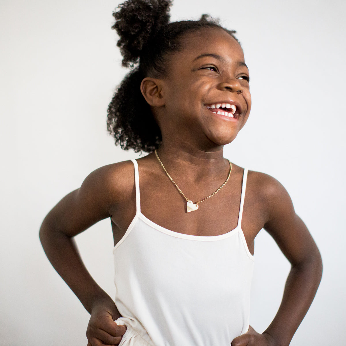 JustOne's brass chain necklace with small white and brass heart charm, handcrafted from ethically sourced bone and brass in Kenya