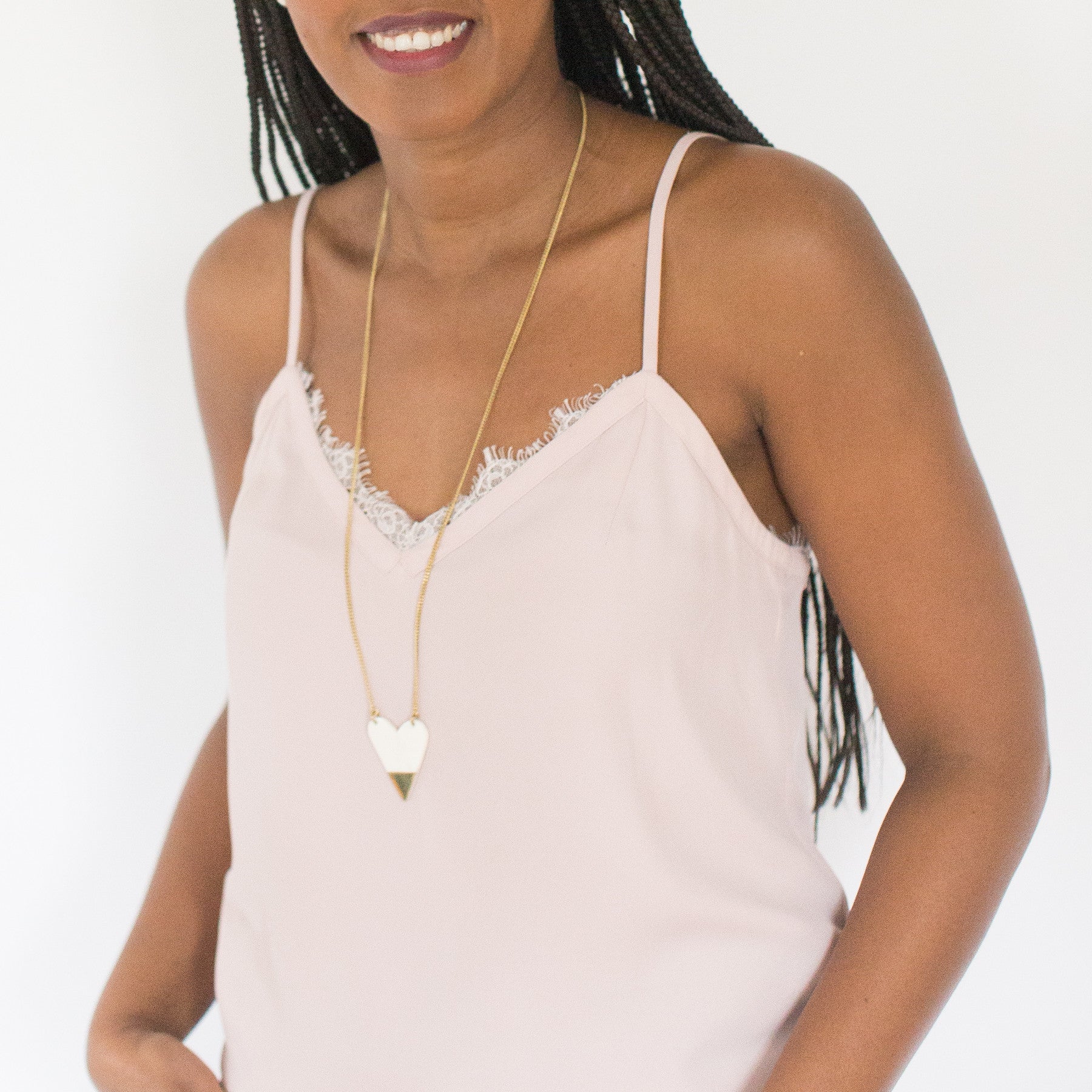 JustOne's long brass necklace with large white and brass heart charm made from ethically sourced bone and brass, handcrafted in Kenya