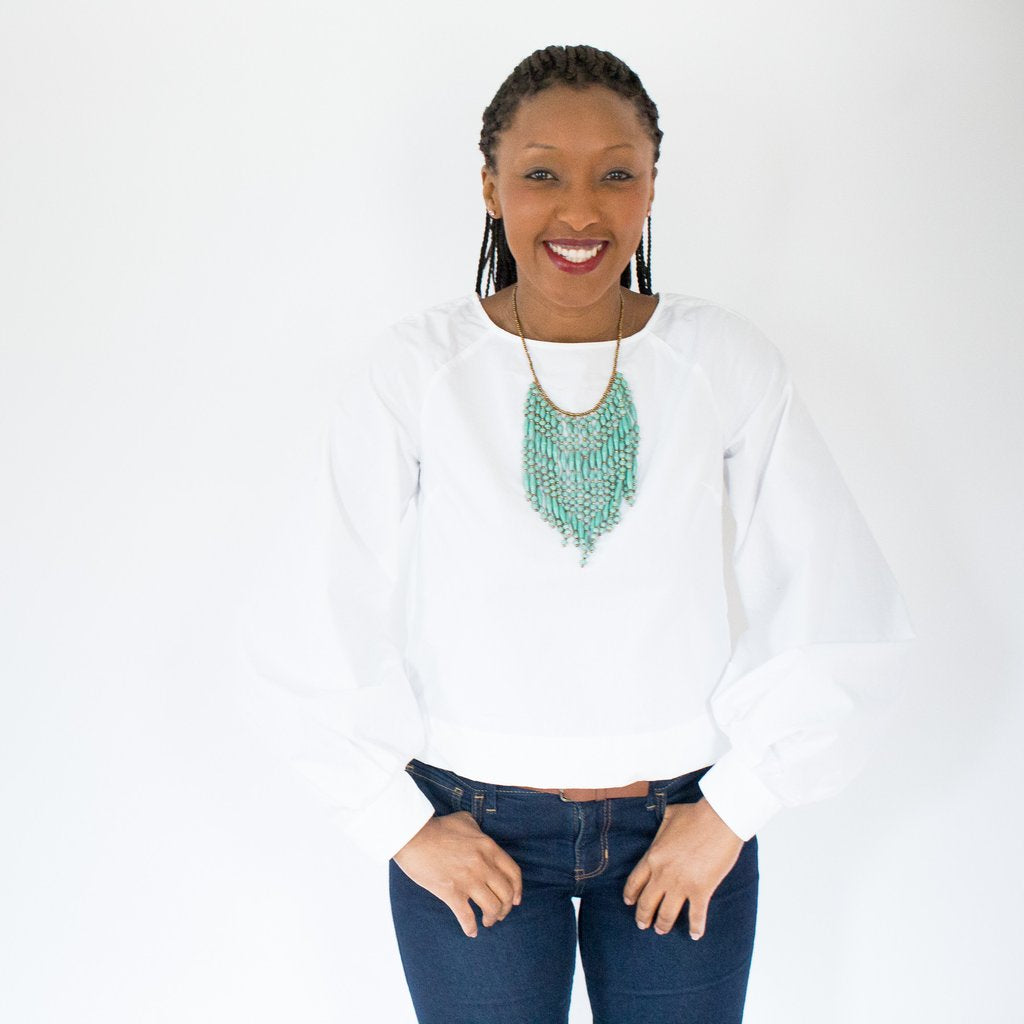 JustOne's necklace with several dangling strings of paper beads in teal, handcrafted in Uganda
