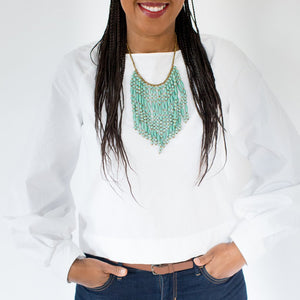 JustOne's necklace with several dangling strings of paper beads in teal, handcrafted in Uganda