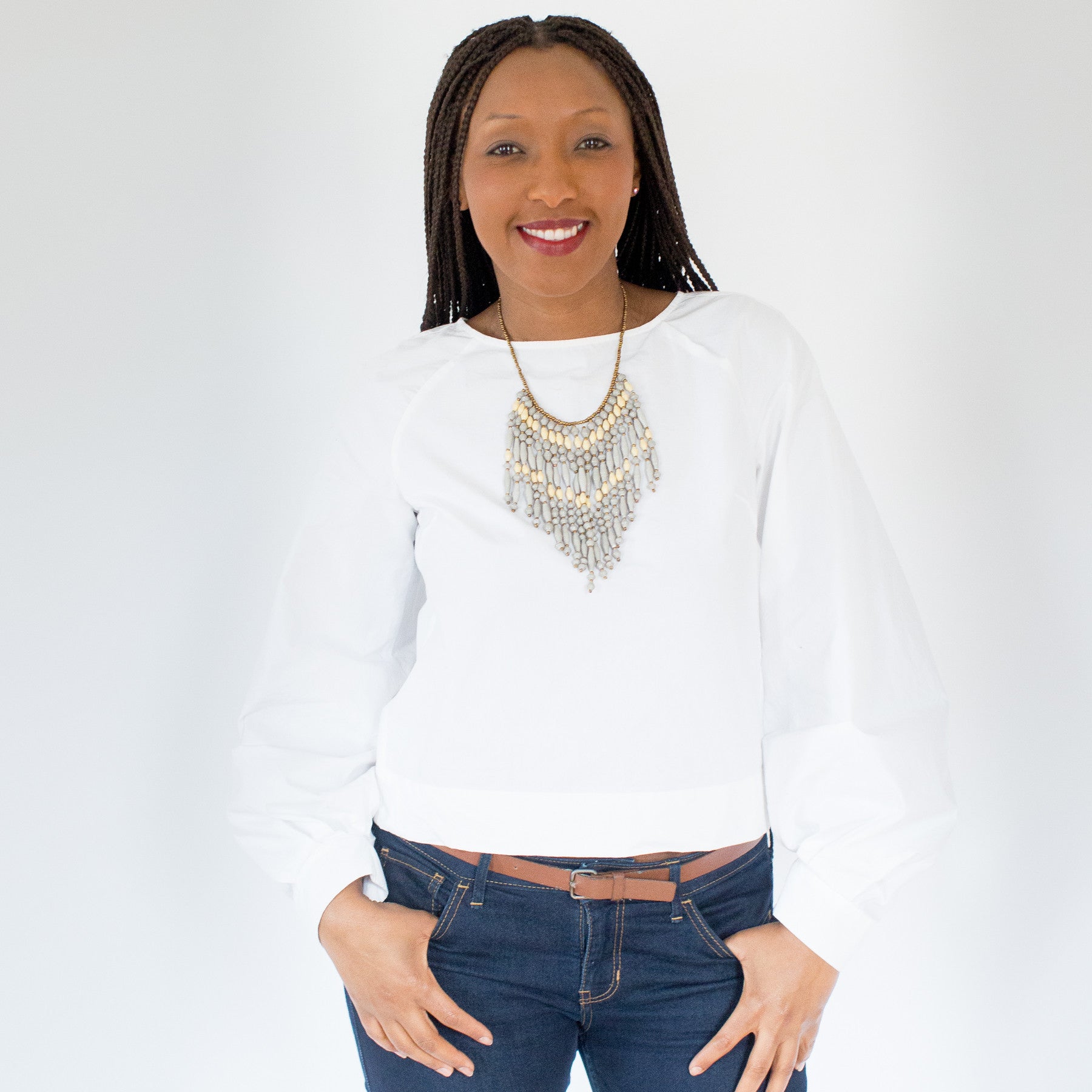 JustOne's necklace with several dangling strings of paper beads in grey and tan colours, handcrafted in Uganda