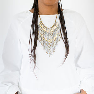 JustOne's necklace with several dangling strings of paper beads in grey and tan colours, handcrafted in Uganda