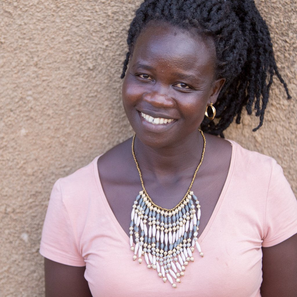 JustOne's necklace with several dangling strings of paper beads in grey, pink,  and tan colours, handcrafted in Uganda