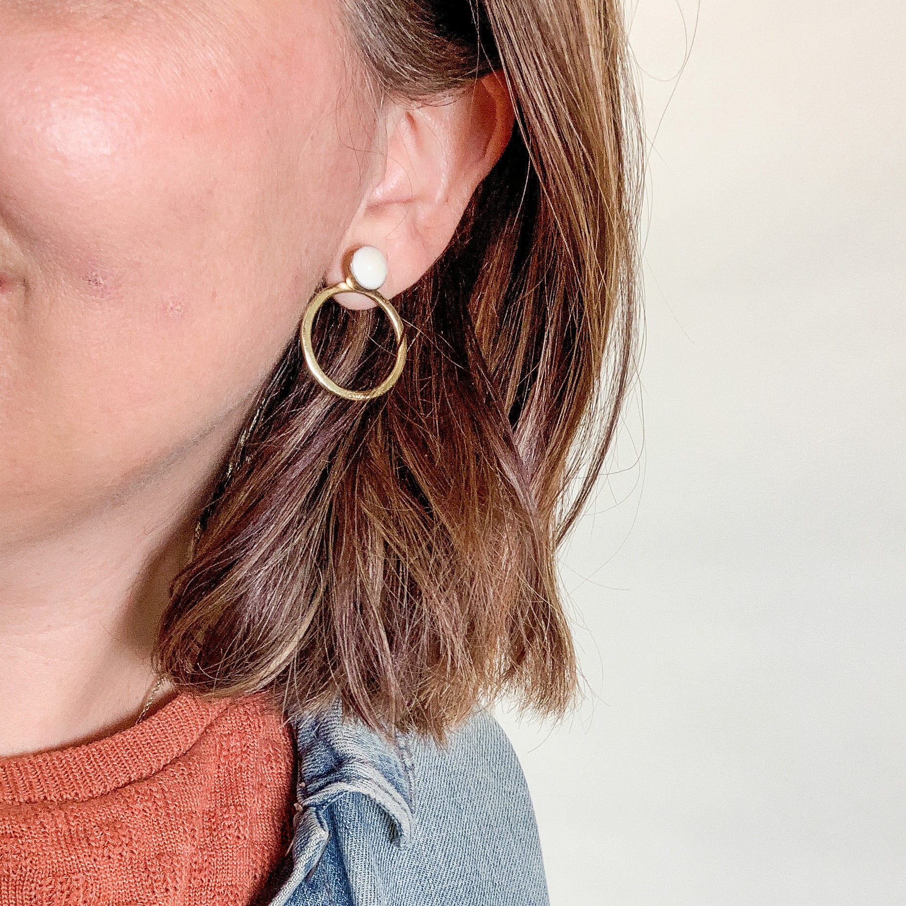 JustOne's brass hoop earrings with detachable white circle stud at the top, ethically made from recycled materials in Kenya